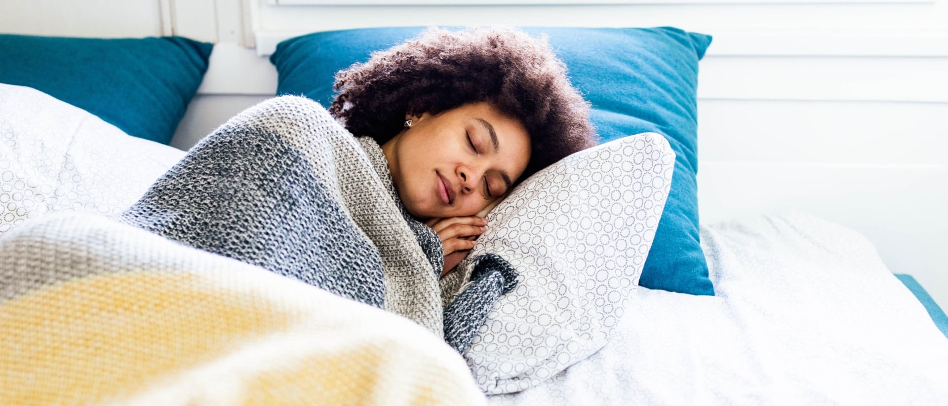 A woman sleeping comfortably on a mattress.