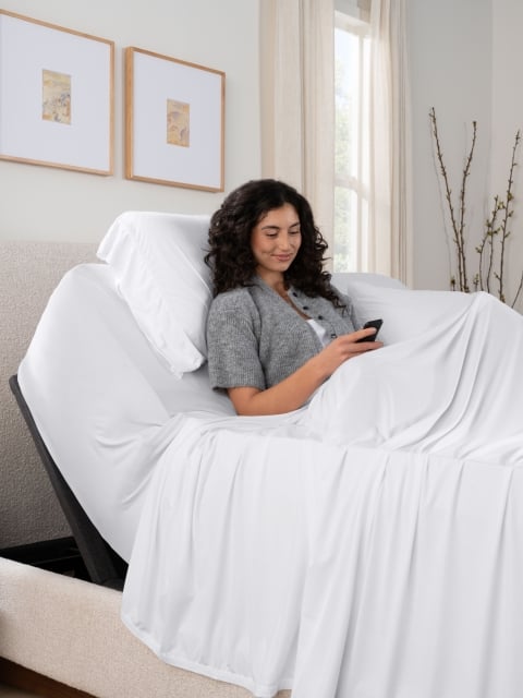 Woman in bed with adjustable base elevated